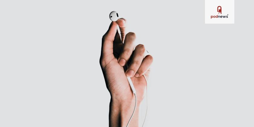 A hand holding some Apple earbuds
