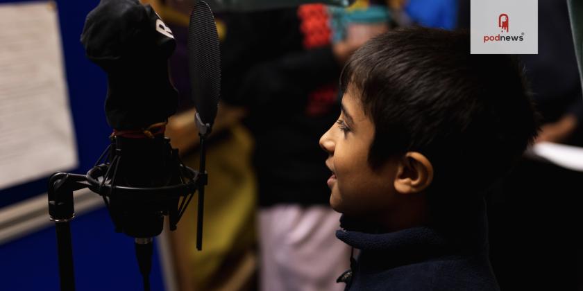 A young boy talking to a microphone