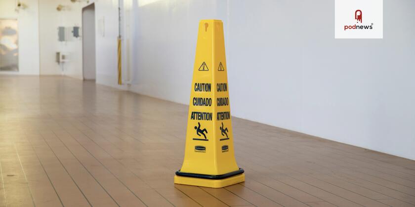 A yellow cone on a floor saying Attention on it