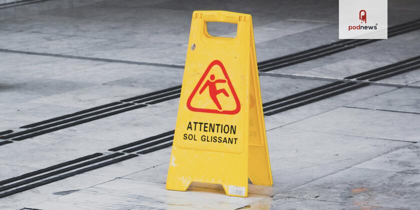 A yellow sign, saying Attention, warning about a slippery floor