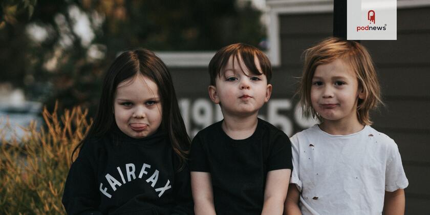 Three kids looking at the camera. One is pulling a silly face.