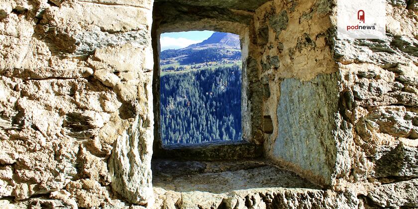 A stone wall, with a small window showing the world beyond it